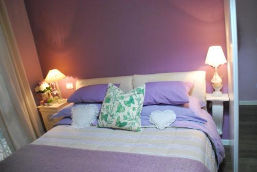 1 dormitorio con 1 cama con paredes y almohadas moradas en Villetta Gaia, en Colle Umberto
