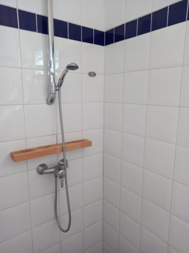 a shower in a bathroom with white tiles at studio 105 hamaca grand bourg marie galante in Grand-Bourg