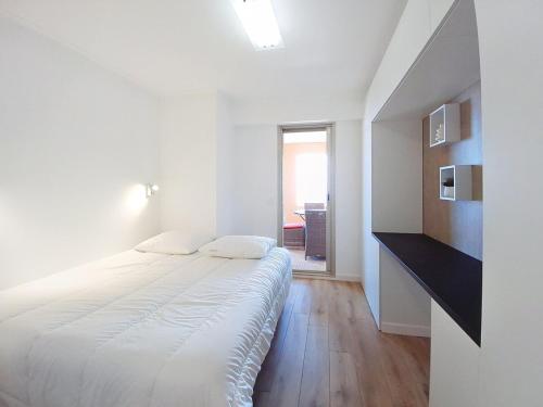 - une chambre blanche avec un grand lit blanc dans l'établissement Superbe appartement 3P rénové dans le Domaine du Grand Duc, à Mandelieu-la-Napoule