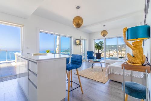 a kitchen and living room with a view of the ocean at Pearl Sesimbra in Sesimbra