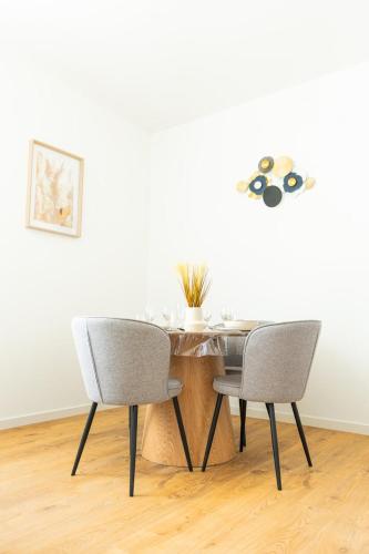 - une table à manger avec 2 chaises et une table dans l'établissement Le Châlons Cosy T2 calme, à Châlons-en-Champagne