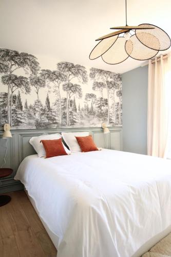 - une chambre avec un grand lit blanc et un lustre dans l'établissement L'élégance aux portes des caves, à Reims