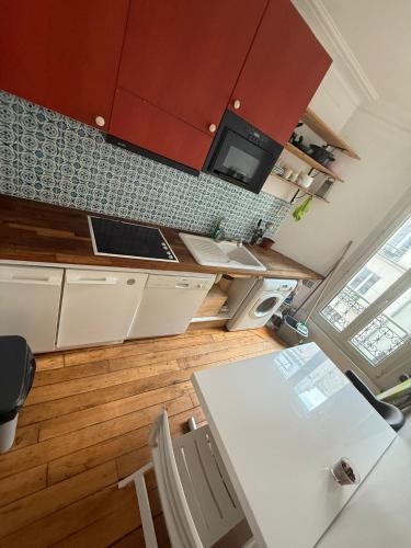 une cuisine avec une table et des chaises dans une pièce dans l'établissement Appartement parisien 2 pièces, à Paris