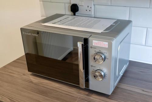a microwave oven with a paper on top of it at Single room in brand new 5 bedroom home BW Room 2 in Olton
