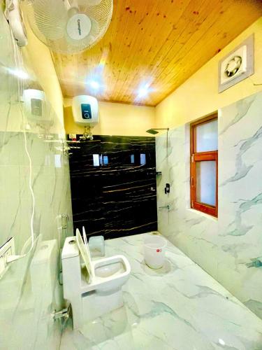 un baño con lavabo e inodoro en ZenRoofs- Cloud Haven 5BHK Villa, en Mussoorie