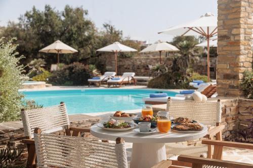 a table with food and drinks next to a pool at Villa Marandi Luxury Suites in Stelida