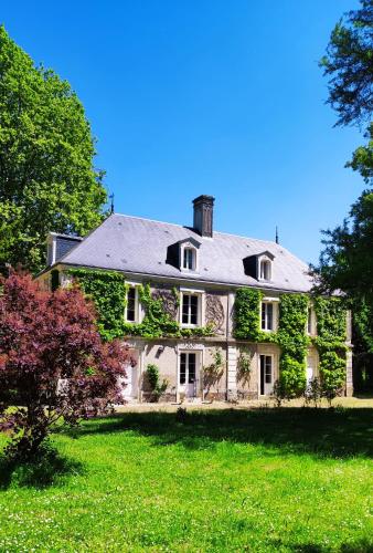 an ivy covered house with a green yard at Chambres d'hôtes du domaine de l'Isle in Civray-de-Touraine