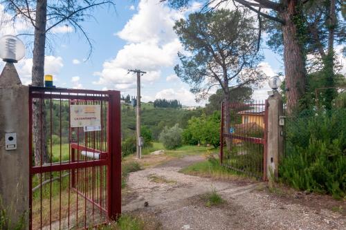 an entrance to a garden with a red gate at La Cantinetta Di Barberino in Greve in Chianti