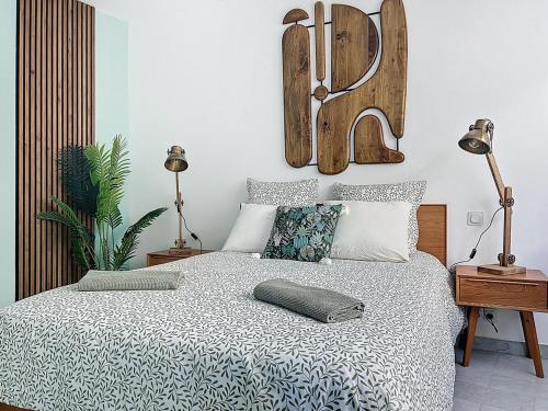 une chambre avec un grand lit avec une tête de lit en bois dans l'établissement Appartement climatisé, 2 chambres, plage Mourillon, à Toulon