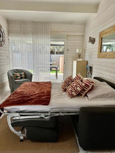 une chambre avec un grand lit avec des oreillers dessus dans l'établissement Studio Plein sud -Histoire de clés, à Agde