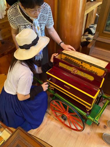 a woman sitting on the floor with a cart of organ at 貸別荘MUSIC FOREST by MFR in Sasayama