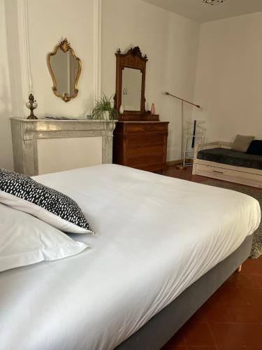 a white bed in a bedroom with a mirror at Entre Midi - Maison d'Hôtes - B&B in Capestang