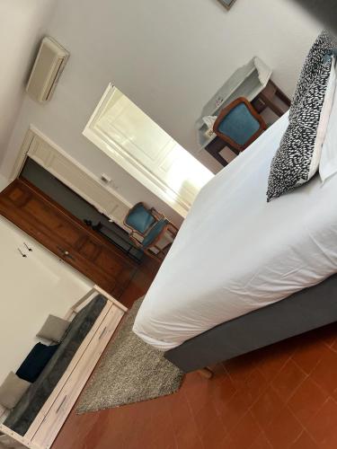 a bedroom with a bed and two blue chairs at Entre Midi - Maison d'Hôtes - B&B in Capestang