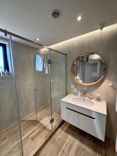 a bathroom with a shower and a sink and a mirror at Glavinitsa Luxury Suites, Главиница in Glavinitsa