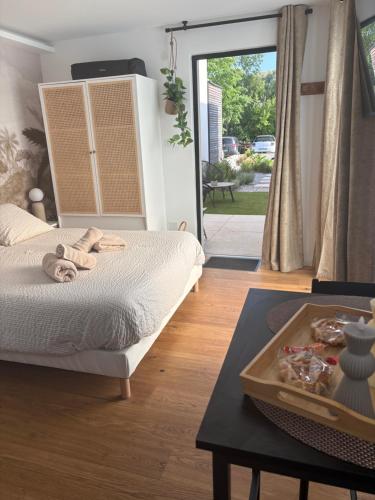 a bedroom with a bed and a table with towels on it at Le Chêne Doré & Jacuzzi Spa privatif Amnéville 2 min site touristique in Amnéville