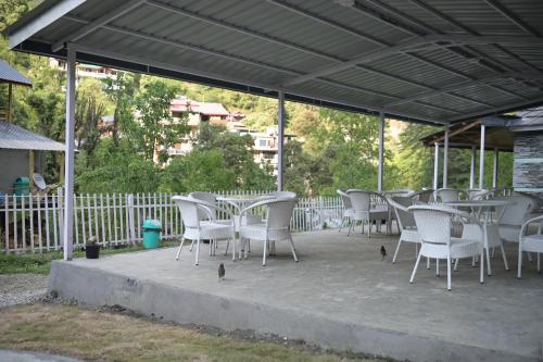 a group of tables and chairs on a patio at Jibhi Village in Jibhi