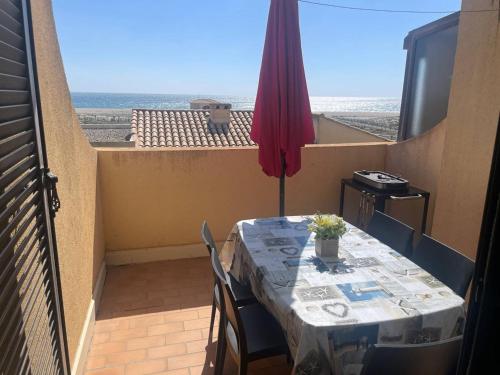 - une table sur un balcon avec vue sur l'océan dans l'établissement Maison T2 face mer avec parking privé, 4 couchages - FR-1-81-48, à Port-Leucate