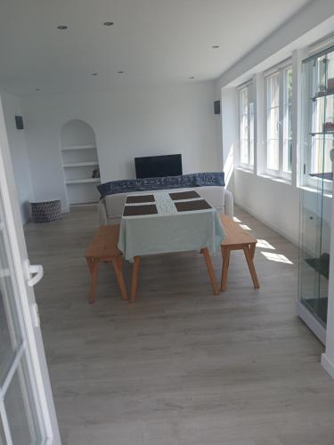 a living room with a table and a laptop on a couch at Chambre tout confort in Beynac-et-Cazenac