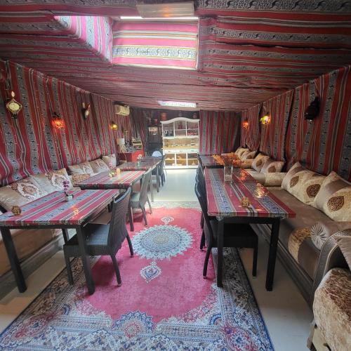 een kamer met tafels en banken en een bank bij Hôtel Le Chalet in Valras-Plage