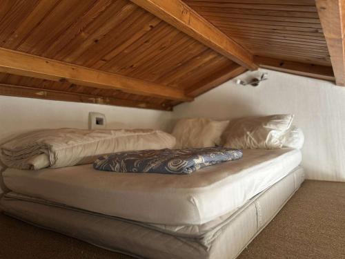 un lit dans une chambre avec un plafond en bois dans l'établissement Studio Mezzanine à 200m du Port et de la Plage, Cour Privative, Parfait pour 3 Personnes - FR-1-224B-564, à Noirmoutier-en-l'lle