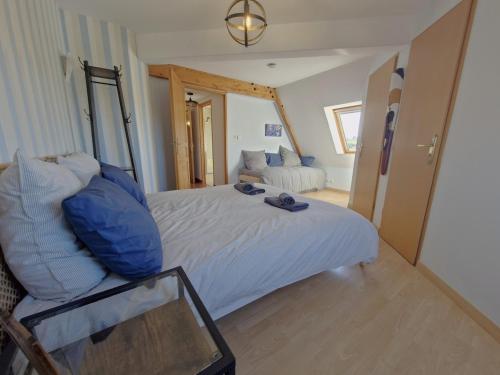 une chambre avec un grand lit blanc et un canapé dans l'établissement Ty Nomad, à Plougonvelin