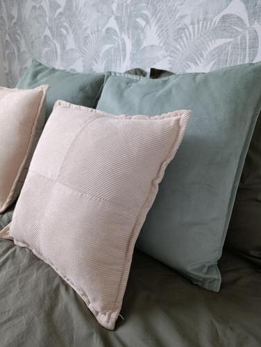 - un oreiller assis au-dessus du lit avec des oreillers dans l'établissement Chambre privée sur Concarneau, à Concarneau