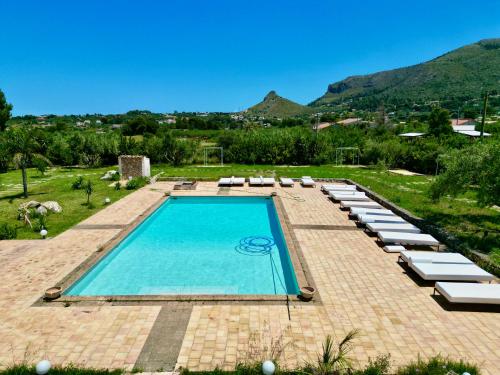 a swimming pool with lounge chairs and a resort at Zingaro Retreat - Scopello - 5min from the sea - AC, Wifi & Pool in Castellammare del Golfo