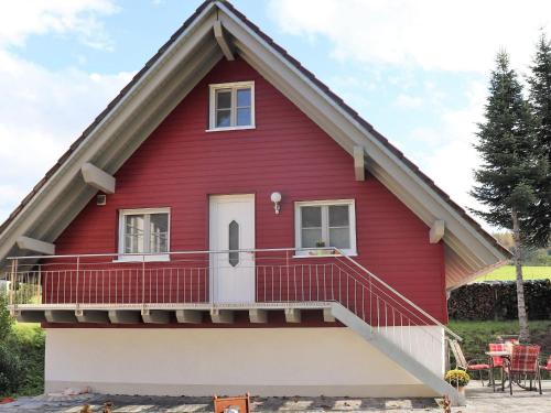 a red house with a porch and a balcony at Ferienwohnungen Braun in Seelbach