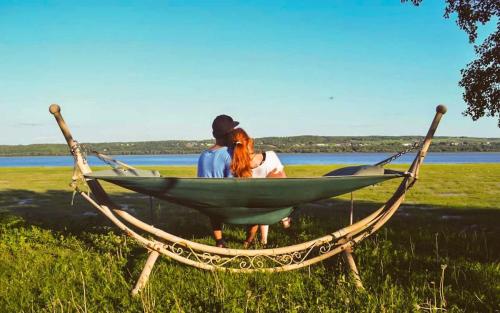 two people sitting in a hammock in a field at Studio 8 - 2 min du Bord de l'eau Foyer & Barbecue in Sainte-Anne-de-Beaupré