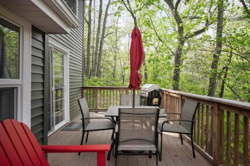a deck with a table and chairs and an umbrella at Secret Gardens Fireplace Deck & Dog-Friendly in Inwood