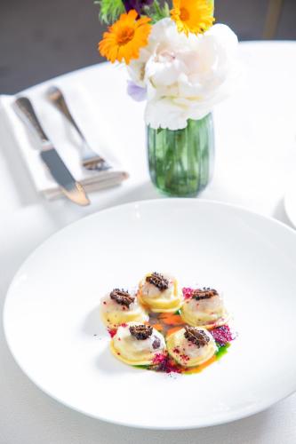 a plate of food on a table with a vase of flowers at Blu Suite Resort in Bellaria-Igea Marina