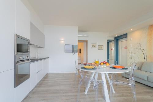 a kitchen and dining room with a white table and chairs at Valarin Luxury Apartments & Wellness, Vercana by Rent All Como in Vercana