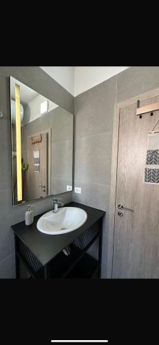 サランダにあるFlorentina Apartamentsの洗面台と鏡のあるバスルーム