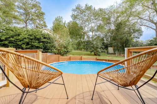 two chairs sitting on a deck next to a pool at Fenced Yard 10 Mins to Lake Murray in Columbia