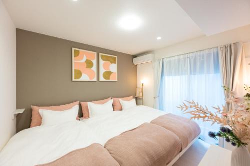 a bedroom with a large bed with a large window at Pines Sakuragi-cho in Omiya