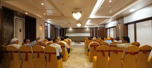 a group of people sitting in chairs in a room at Hotel Abhinav International in Varanasi