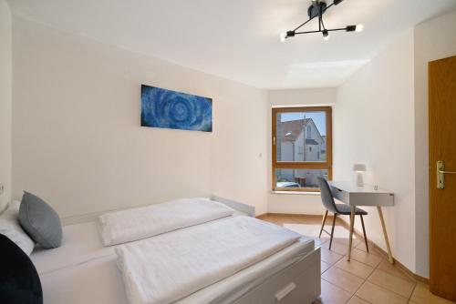 下乌尔丁根Seeside的一间卧室，配有一张床、一张书桌和一扇窗户