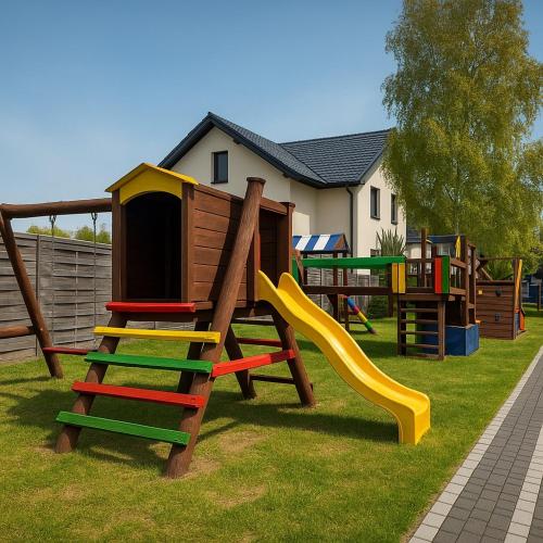 a playground with colorful play equipment in a yard at Resort EDEN - domki, pokoje, apartamenty, sauna, jacuzzi in Jastrzębia Góra