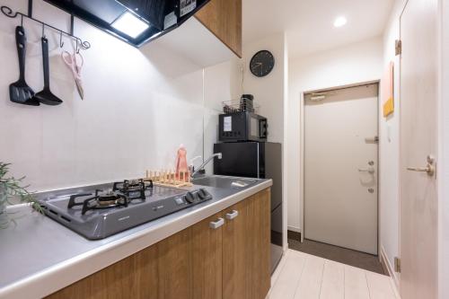 a kitchen with a sink and a stove at Pines Sakuragi-cho in Omiya