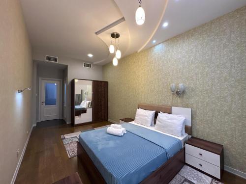 a bedroom with a blue bed and a mirror at Saphire apartment by Bakuapart in Baku