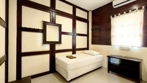 a small room with a bed and a mirror at Gili Buana Hostel & Backpackers Gili Air in Gili Air