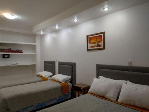 a room with two beds and a picture on the wall at San Remo City Hotel in Buenos Aires