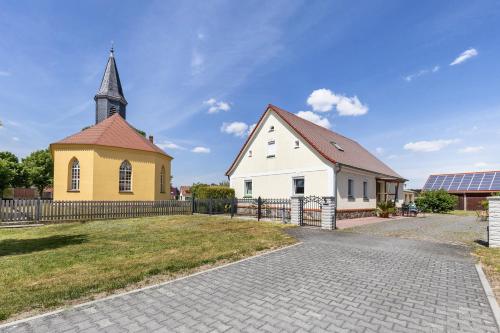a yellow and white church with a steeple at Unser Ferienhaus Sonnenhof Reudnitz in Friedland
