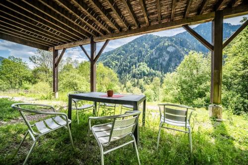 a table and chairs in the grass with a view at Chalet Elisthur in Saint-Jean-dʼAulps