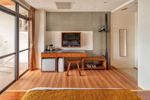 a room with a desk and a table at Sun Moon Lake ItaThao Vacation Inn with Elevator in Yuchi