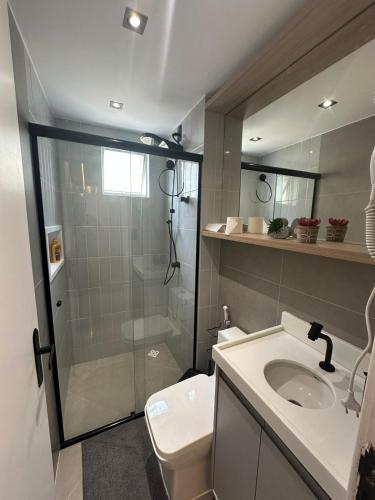 a bathroom with a shower and a sink and a toilet at Apartamento moderno com 2 quartos e cama queen-size in Caruaru