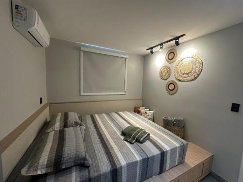 a bedroom with a large bed with a blanket at Apartamento moderno com 2 quartos e cama queen-size in Caruaru