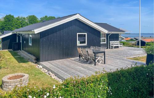 a wooden deck with a table and chairs on a house at Stunning Home In Sjølund With Kitchen in Sjølund