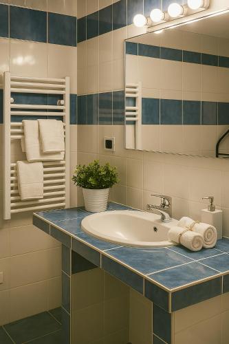 a bathroom with a sink and a mirror and towels at Villa Maria Gaeta in Gaeta