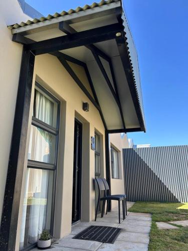awning over a patio of a house with a chair at Mountain Pastures Game Lodge in Uniondale